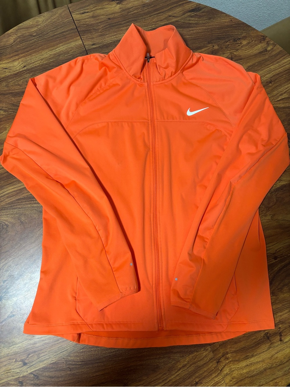Nike Dri-FIT running jacket features a full-zip front and a white swoosh logo.